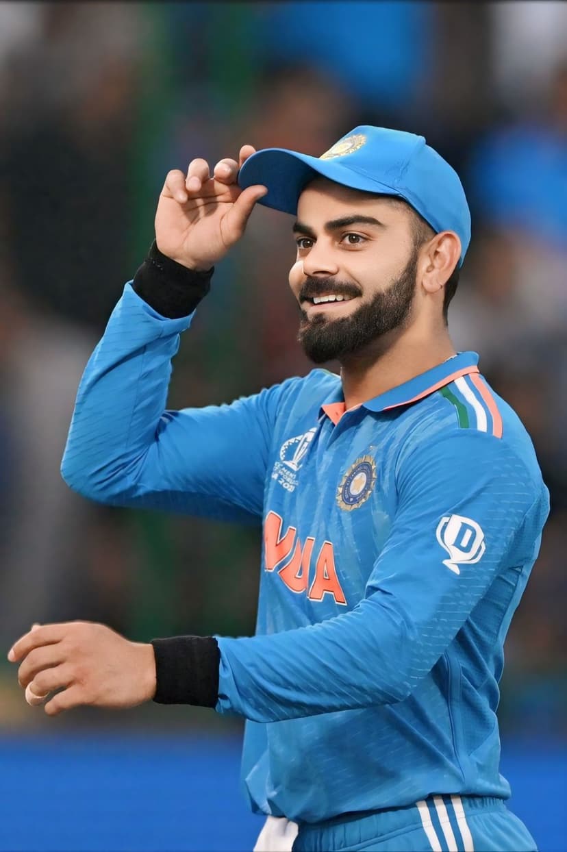 Virat Kohli smiles in a blue India cricket jersey while adjusting a navy baseball cap during the daytime.