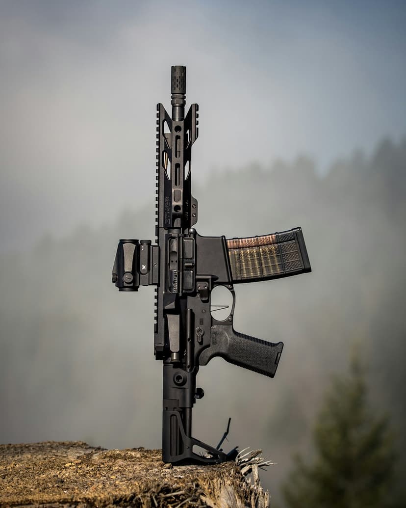 AR-15 rifle with an optic sight and loaded magazine stands vertically on a tree stump in a misty pine forest.