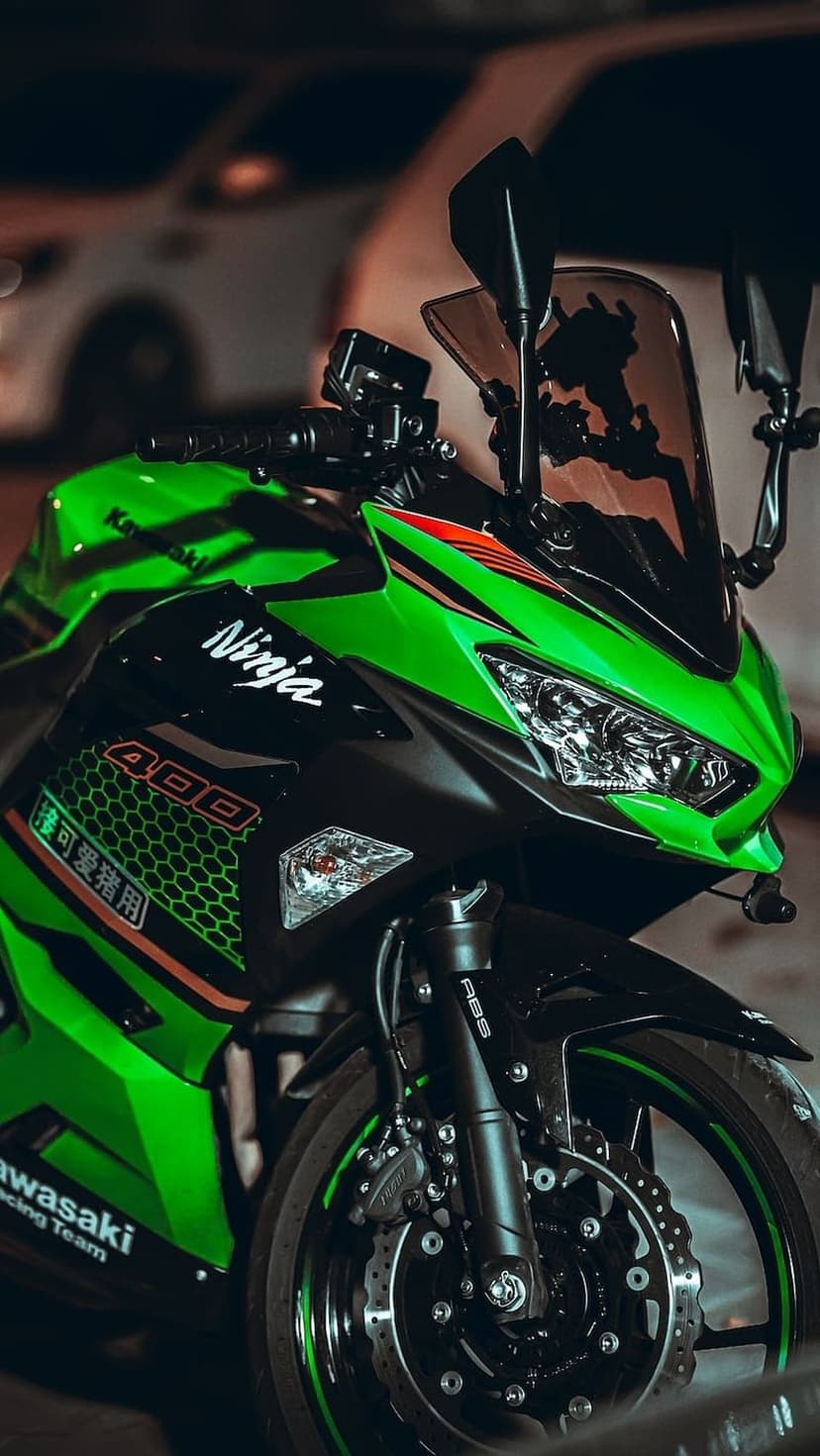 Kawasaki Ninja 400 sportbike in lime green features sharp headlights and an aggressive front fairing design.