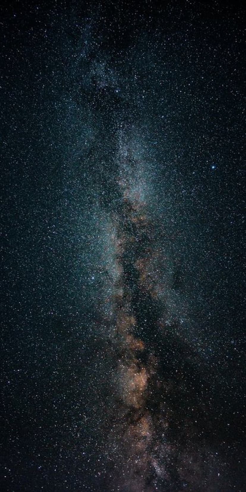 Milky Way galactic core radiates golden and purple light through dense clouds of cosmic dust and distant stars.