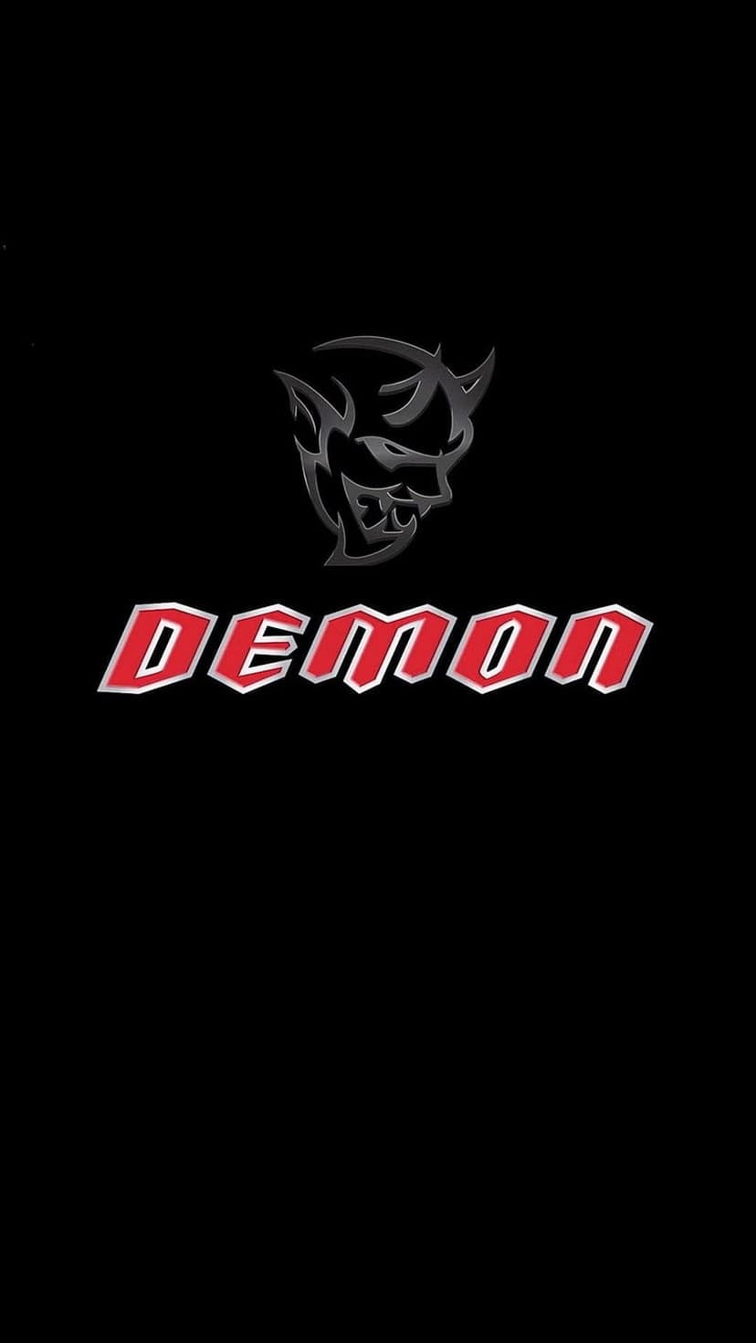 Dodge Demon emblem with a silver face and red stylized text centered on a solid matte black background.