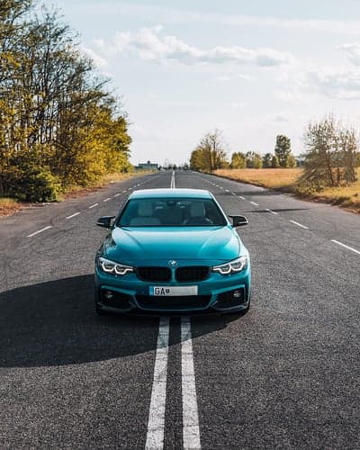 Teal BMW 4 Series Coupe Driving Scene Phone Wallpaper
