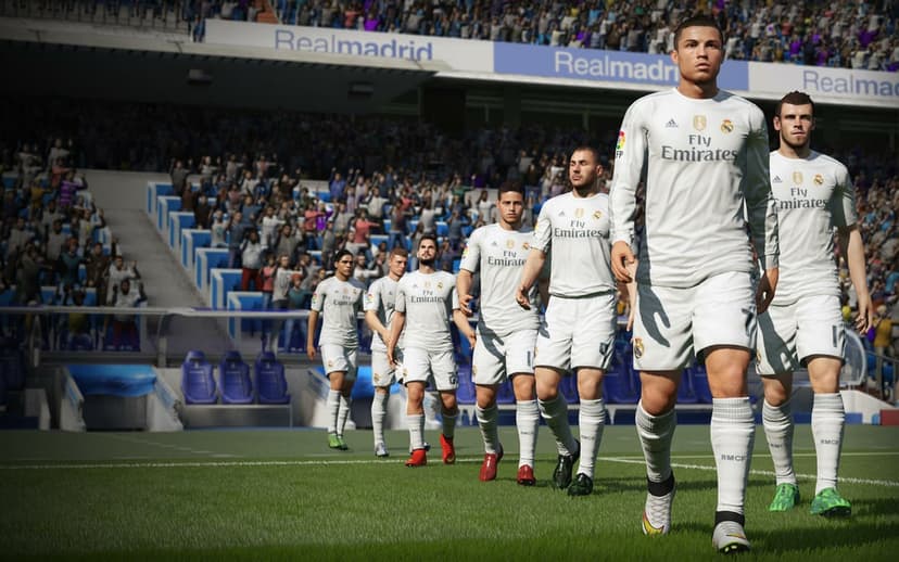 Cristiano Ronaldo leads the Real Madrid team onto a sunny green football pitch inside a crowded stadium.