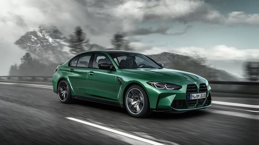 Isle of Man Green BMW M3 sedan driving fast on a mountain road with motion blur and moody cloudy skies.