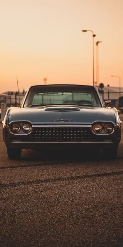Vintage Ford Thunderbird parked at sunset
