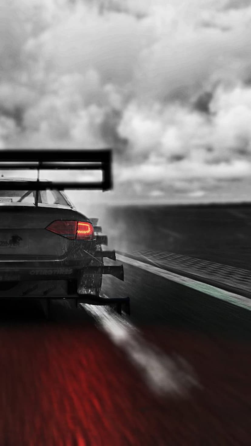 Racing car with a massive rear wing speeds on a wet track under dark clouds with glowing red taillights.