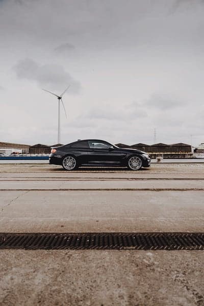 Black BMW M4 Coupe Mobile Wallpaper with Wind Turbine