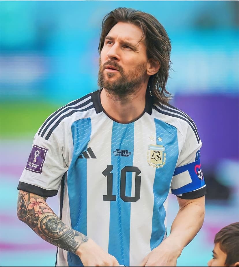 Lionel Messi wearing an Argentina jersey with the number 10 and World Cup patch, looking up in a blurred stadium.