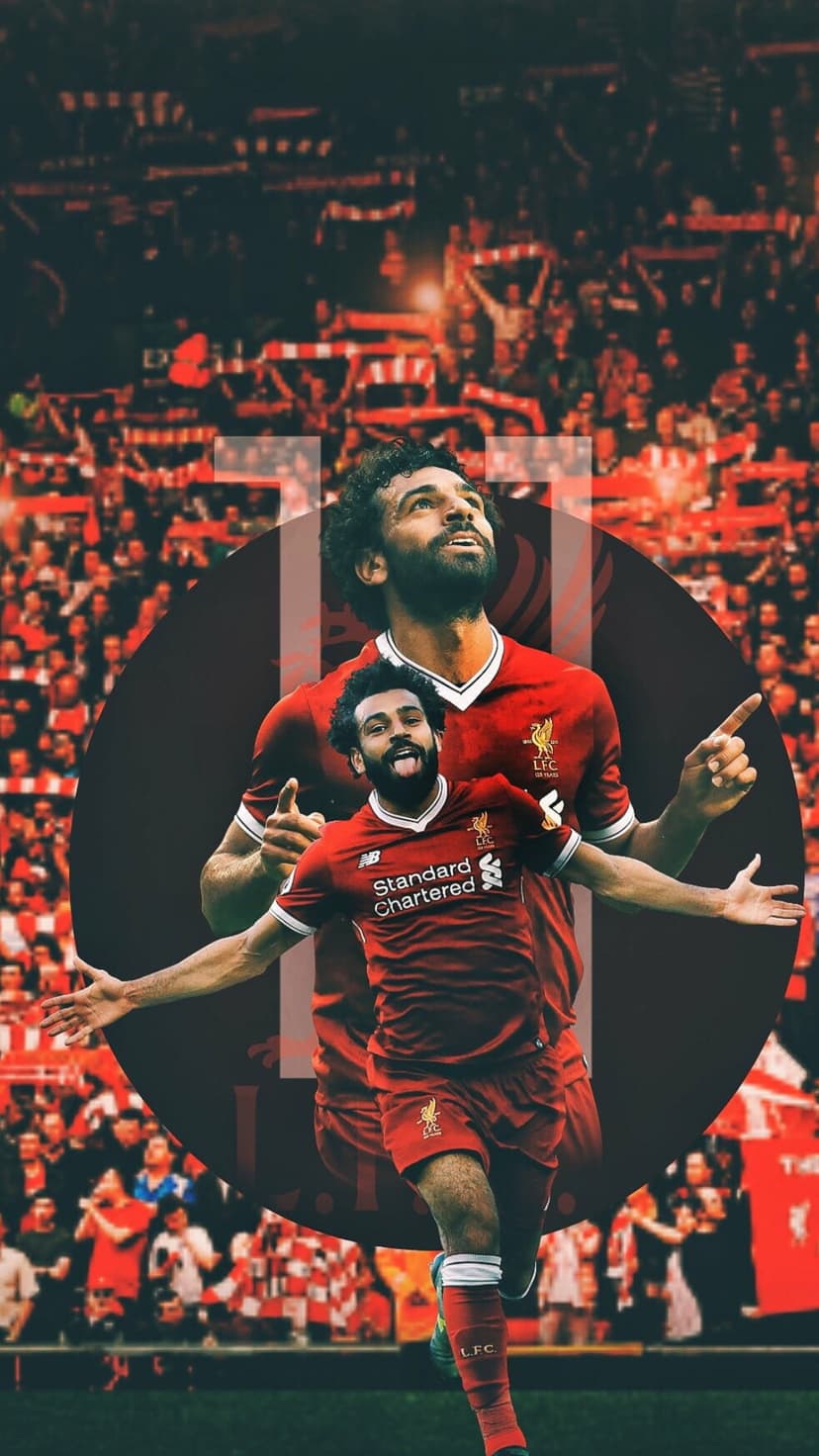 Mohamed Salah raises his arms in celebration wearing a red Liverpool kit in front of a blurred stadium crowd.