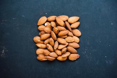 Pile of Almonds on a Dark Textured Background