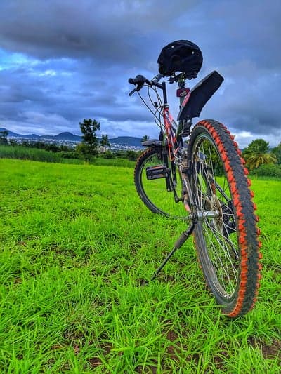 Rugged Mountain Bike on Grassy Hillside Phone Wallpaper