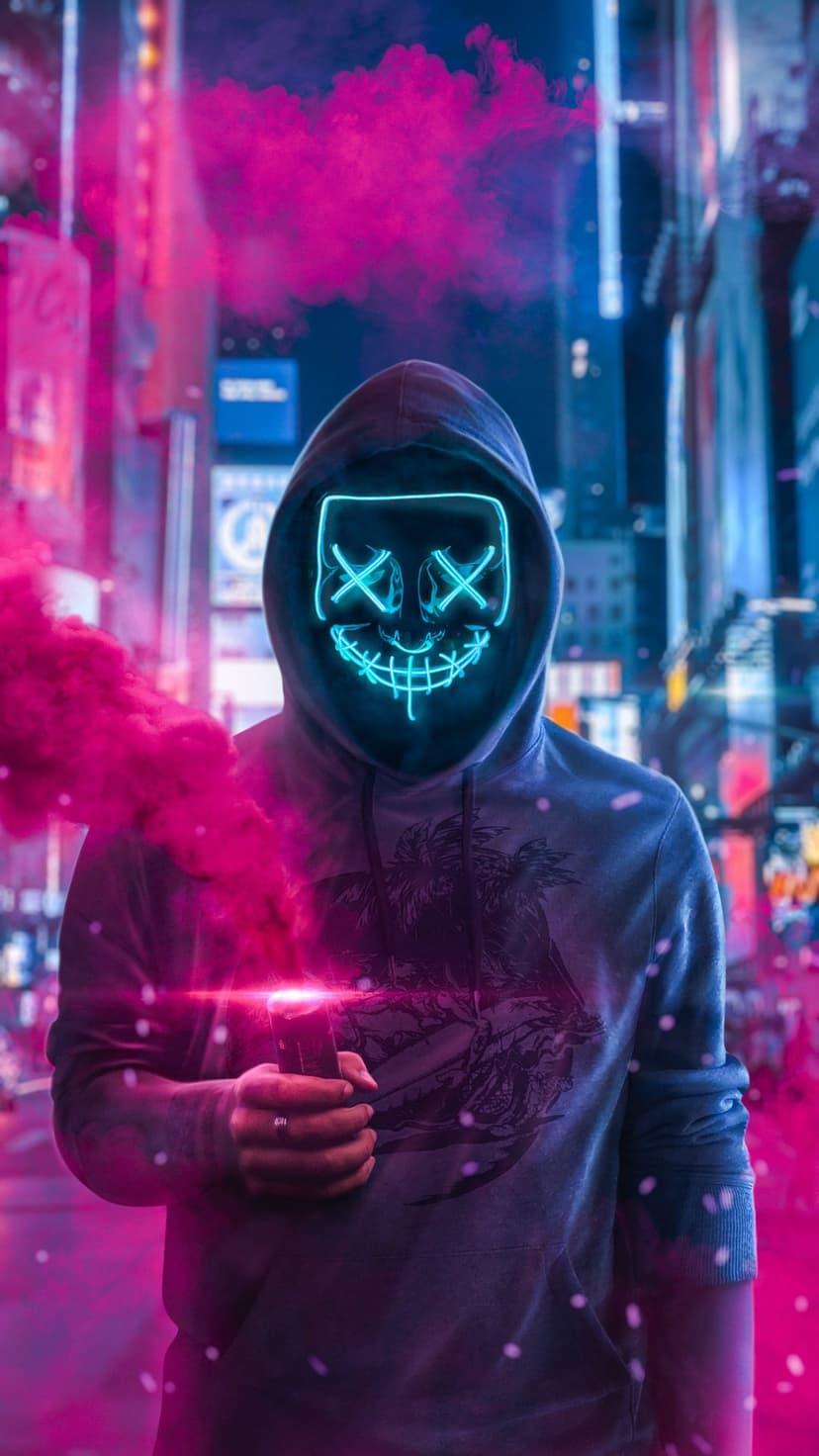 Masked person in a dark hoodie stands as pink smoke rises against a neon blue and purple city street.