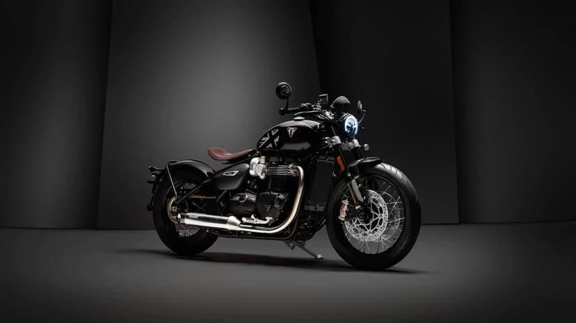 Triumph Bobber TFC motorcycle with Union Jack tank and brown leather seat in a dark minimalist studio.