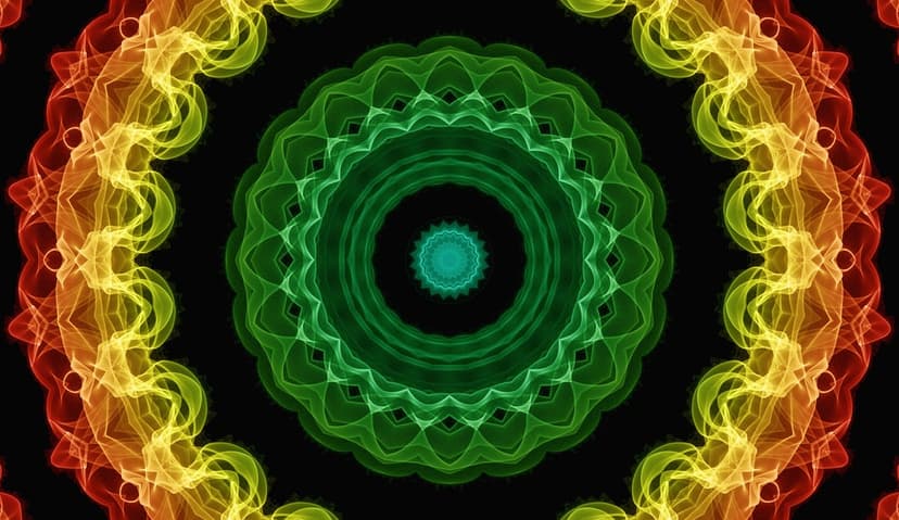 Symmetrical Rasta colored smoke mandala in green, yellow, and red radiating outward on a dark black background.