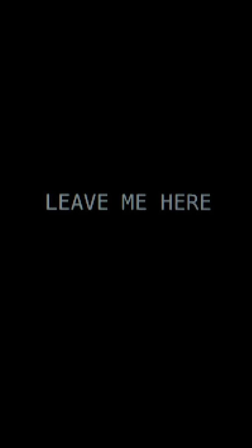 White pixelated Leave Me Here text centered on a solid black background creating a high-contrast minimalist scene.