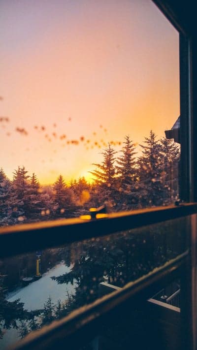 Winter Warmth - Sunrise Through a Snowy Window