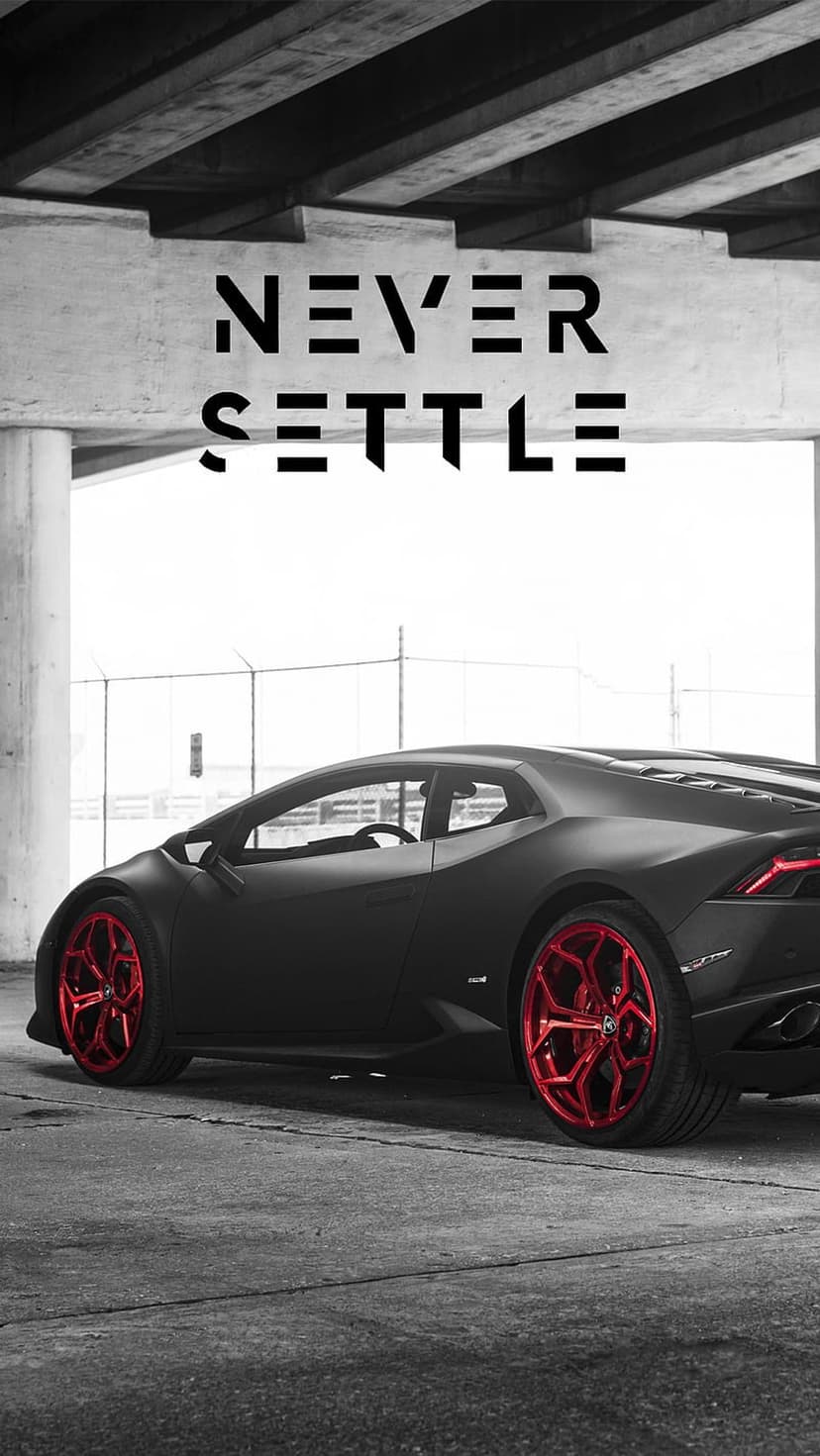 Lamborghini with red wheels parked under concrete beneath a white banner featuring the words Never Settle.