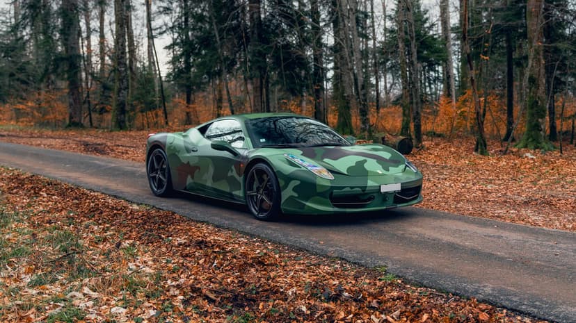 Ferrari 458 Italia supercar with camo wrap features glossy highlights and aerodynamic curves in side profile.
