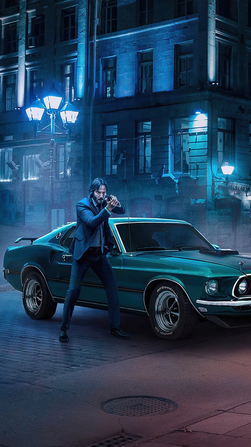 Suit-clad man holding a handgun stands next to a classic teal muscle car on a rainy, blue-lit urban street at night.