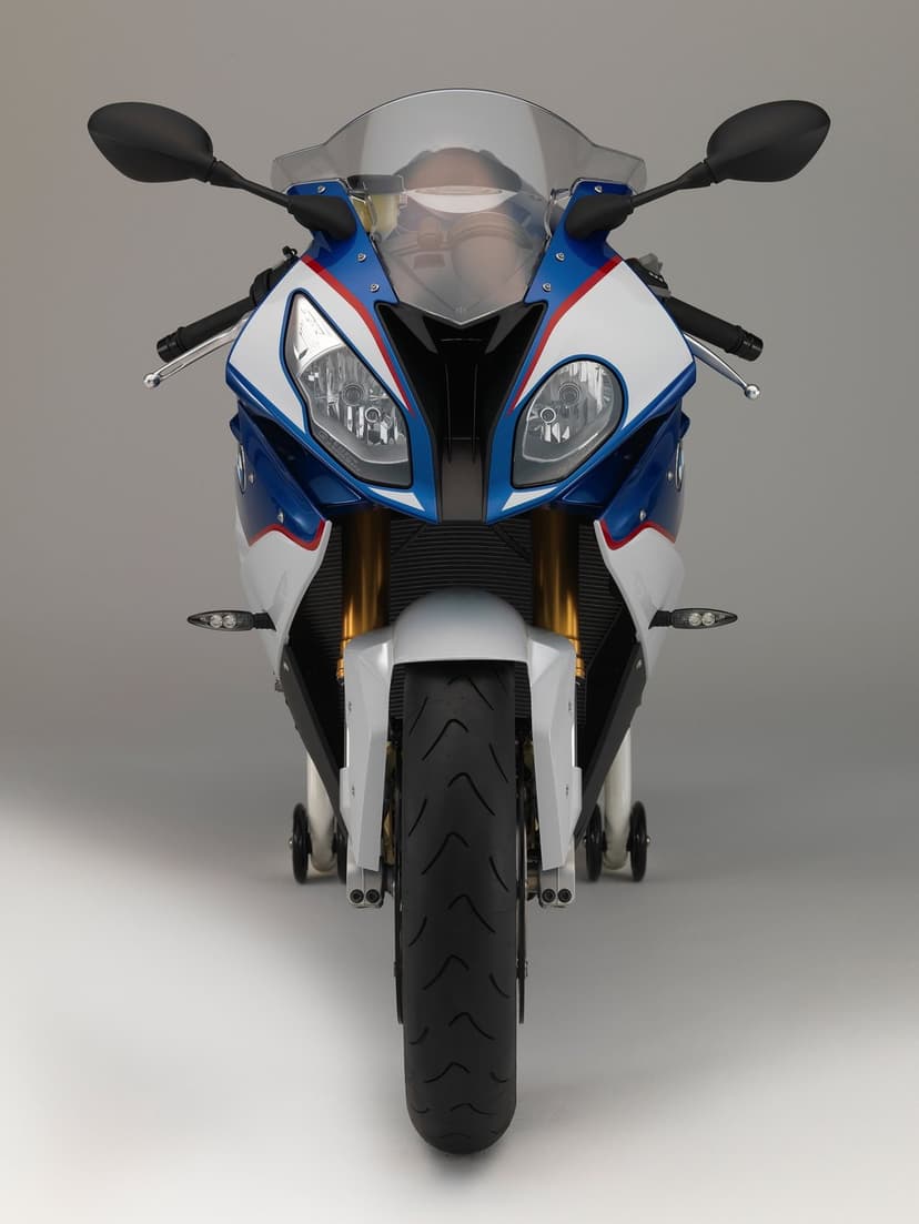 Front view of a blue and white sportbike with asymmetric headlights, gold forks, and a black front tire.