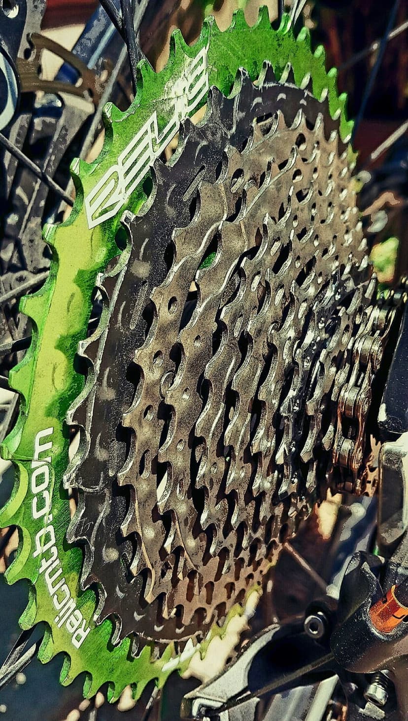 Neon green and silver bicycle cassette gears showing intricate metallic teeth and mechanical sprocket details.