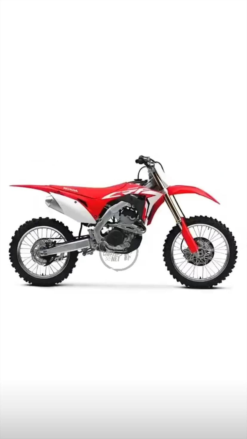 Red Honda CRF dirt bike with knobby tires and white graphics stands against a solid white background.