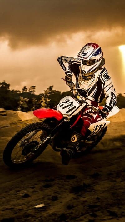 Motocross Rider in Action, Dust and Sunset