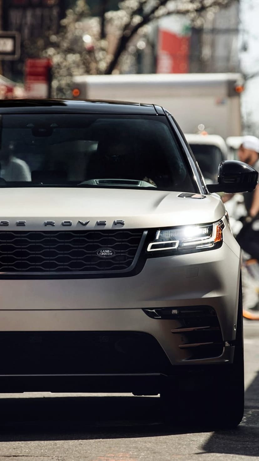 Range Rover Velar LED headlight and black honeycomb grille with silver lettering on a luxury SUV front fascia.