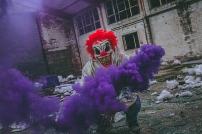 Scary Clown with Purple Smoke in Abandoned Building