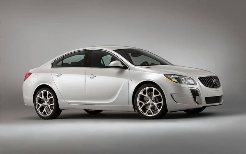 White Buick Regal GS sedan with silver alloy wheels parked in a bright studio with a grey gradient background.