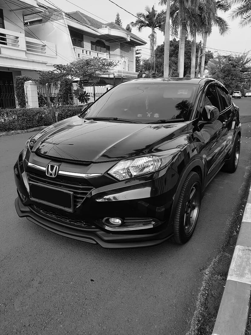 Black Honda HR-V with custom body kit and dark rims parked on a residential street in black and white photography.