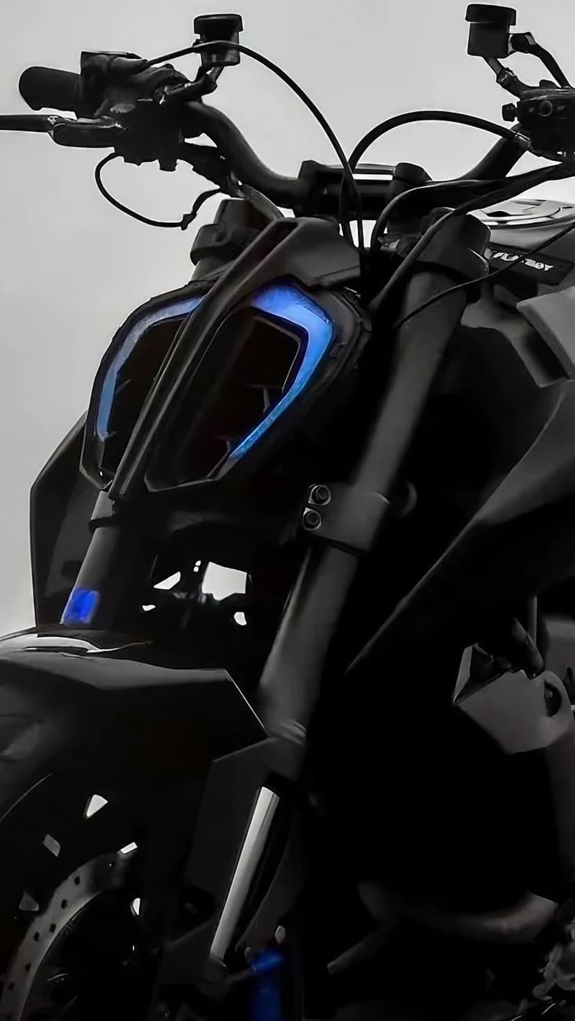 KTM Duke front headlight glows with electric blue LED lights against sharp black matte motorcycle fairing edges.