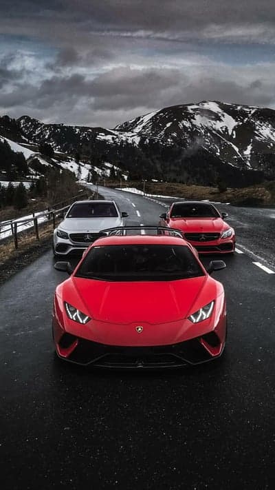 Red Lamborghini and Mercedes Cars on Snowy Mountain Road