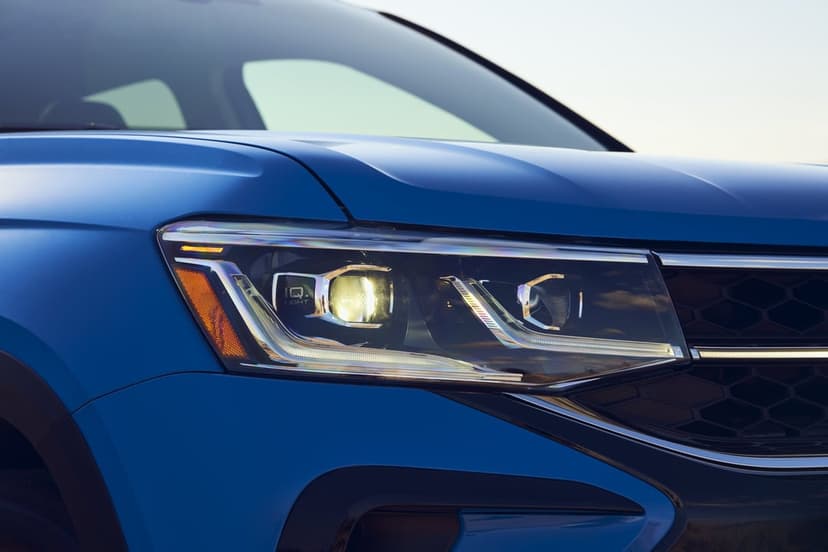 Blue SUV LED headlight with chrome accents and a honeycomb grille captured in soft natural daylight.