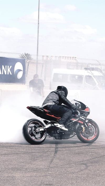 Motorcyclist performs a burnout, creating thick smoke