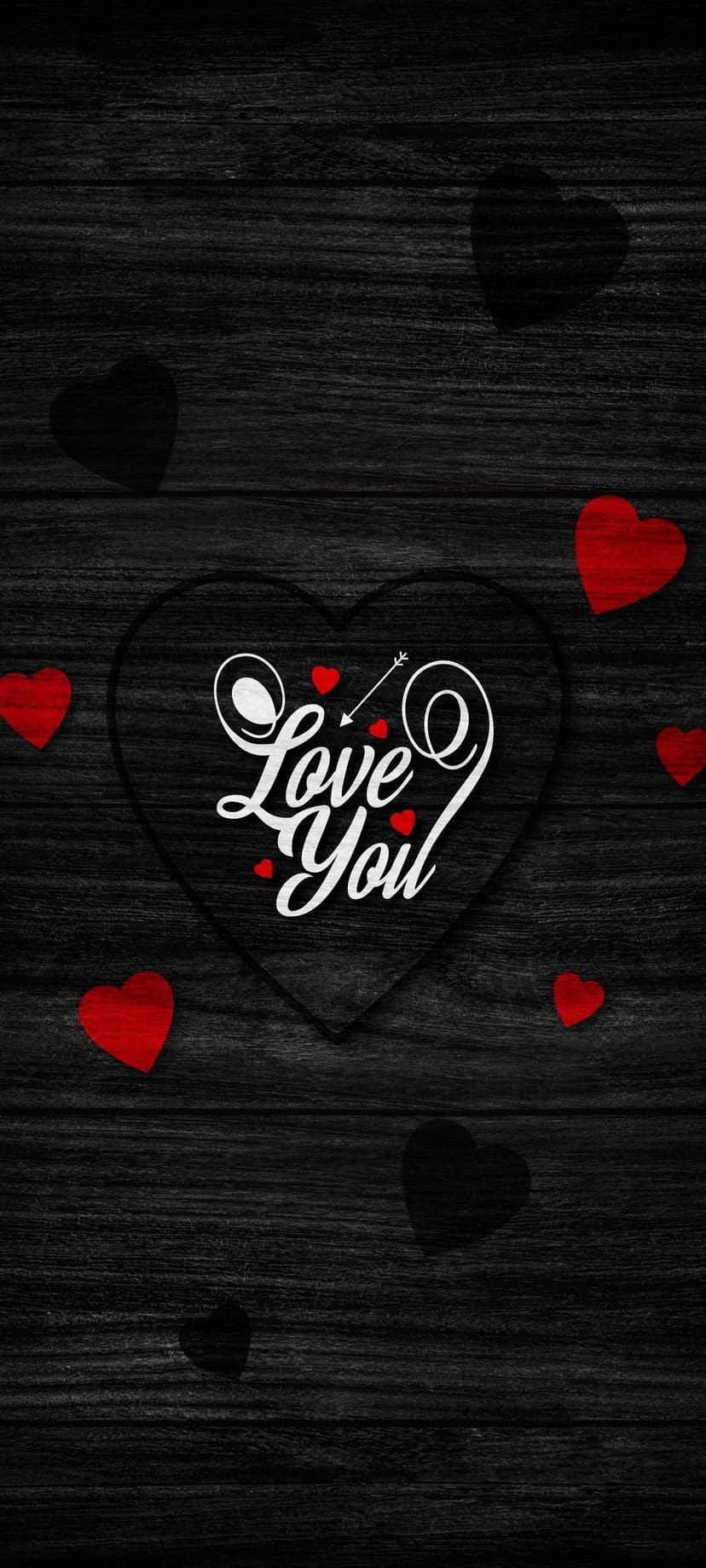 White script Love You text inside a black heart outline on dark wood texture with tiny red heart accents.