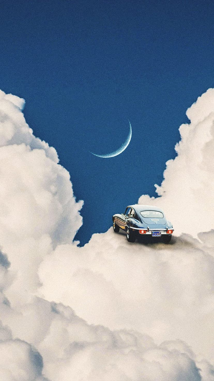 Dark blue classic car driving on white fluffy clouds toward a thin crescent moon in a deep blue midnight sky.