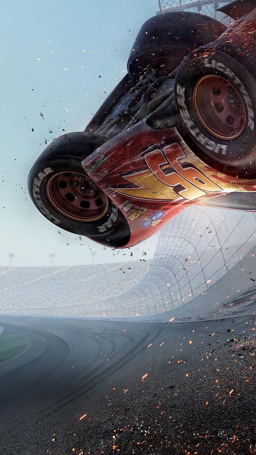 Lightning McQueen crashes upside down mid-air over a banked race track with flying debris, sparks, and smoke clouds.