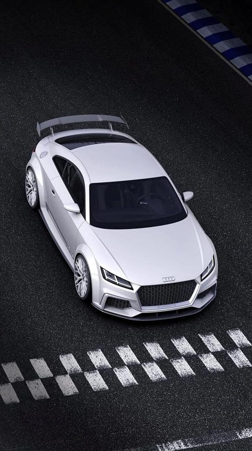 White Audi TT RS on a dark asphalt race track with a checkered finish line and blue and white striped curbs.