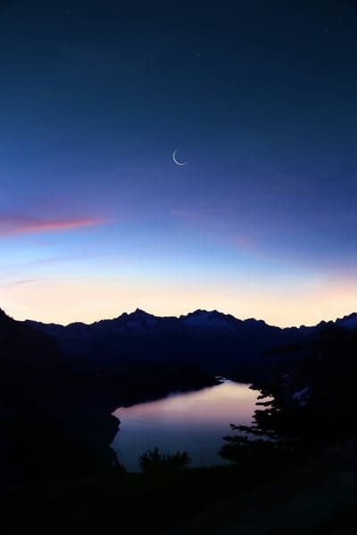 Crescent Moon Over Mountain Lake at Twilight