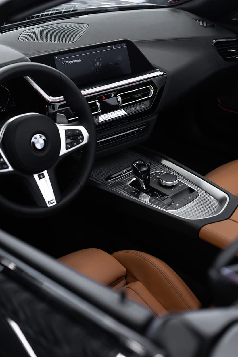 Tan leather BMW Z4 seats face a digital infotainment screen and a detailed dashboard in a vertical view.