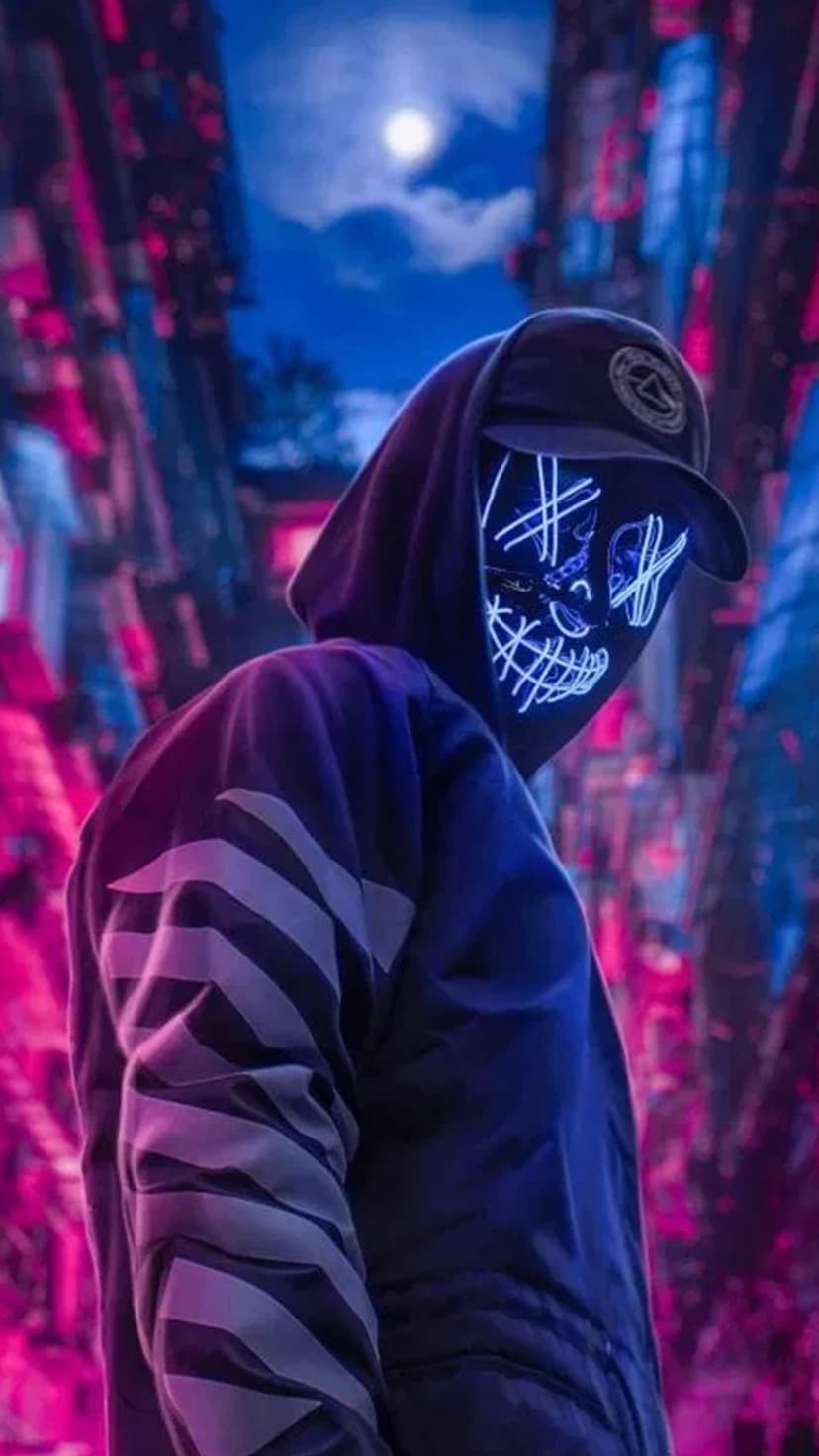 Masked figure in a hoodie with glowing blue and pink facial outlines standing before a night cityscape.