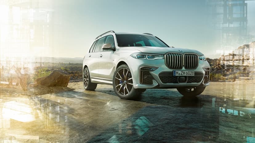 Silver luxury SUV parked on rugged rocky desert ground under a bright sky with modern architectural overlays.