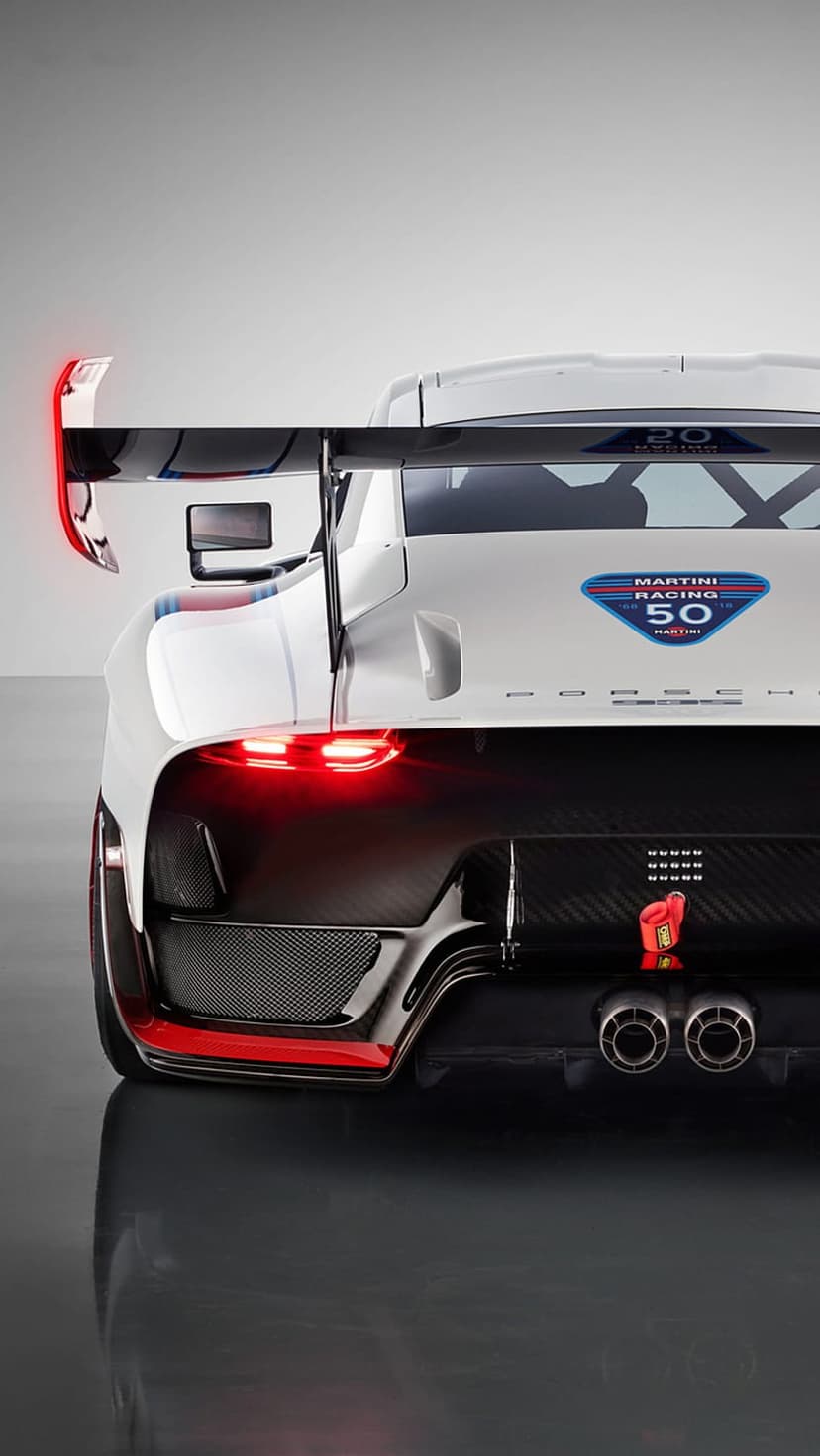 Porsche race car rear view featuring Martini Racing livery, a large spoiler, red taillights, and carbon fiber diffuser.