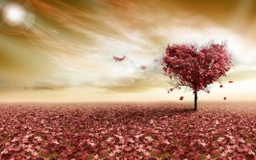 Heart-shaped tree with red foliage stands in a field of fallen leaves under a hazy orange sun with small birds.
