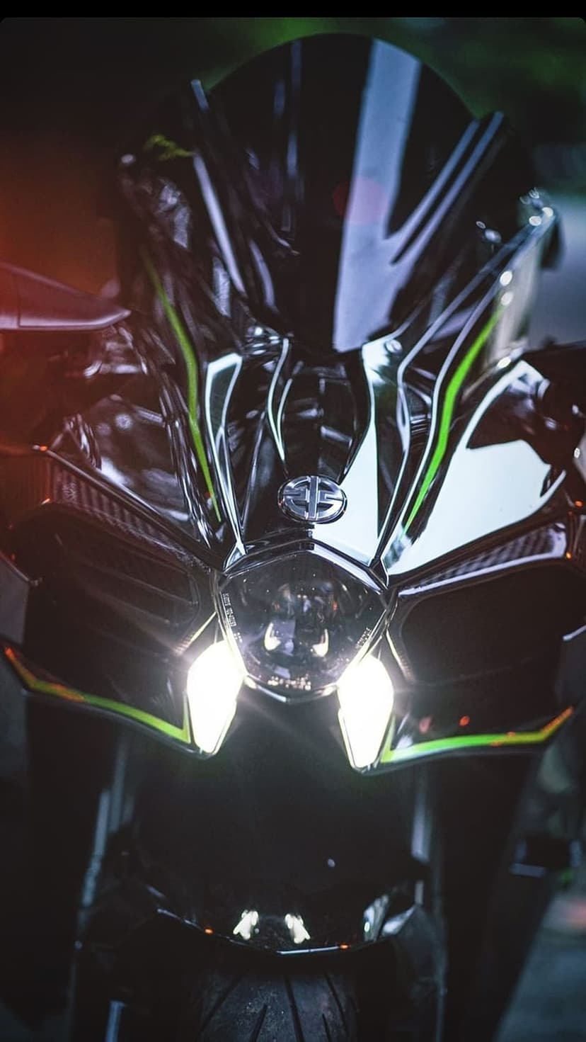 Kawasaki Ninja H2R motorcycle front view with glowing LED headlights and green fairing accents in a close-up shot.