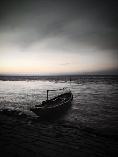 Lonely boat on dark water at dusk
