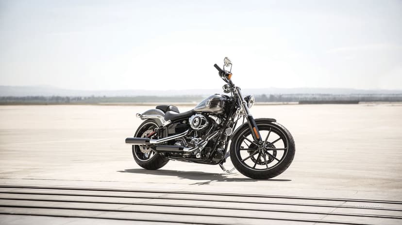 Black Harley-Davidson Breakout motorcycle parked on a wide concrete runway under a bright, clear, pale sky.