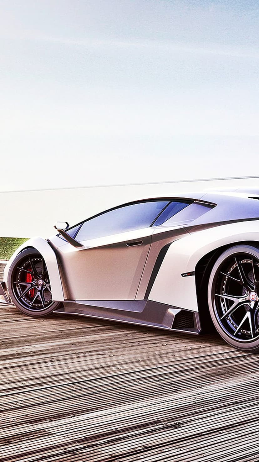 White supercar with black wheels and red calipers parked on a wooden deck against a bright cloudy sky background.
