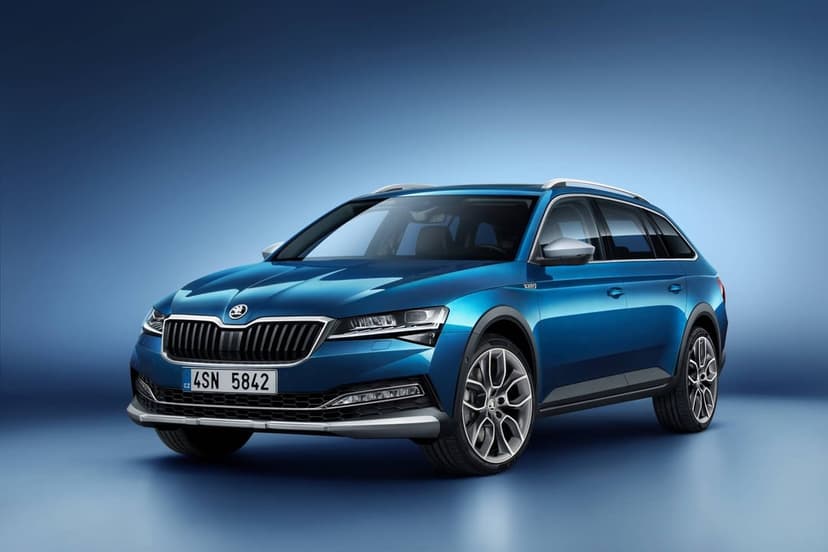 Blue Skoda Superb Scout estate car with silver roof rails and alloy wheels against a blue studio background.